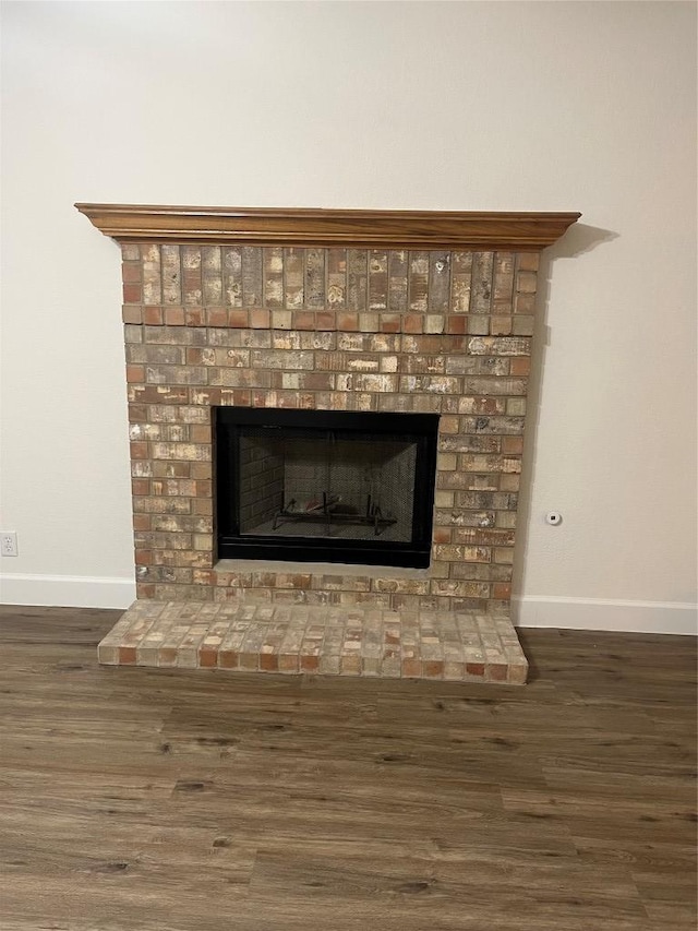 room details with a fireplace, wood finished floors, and baseboards