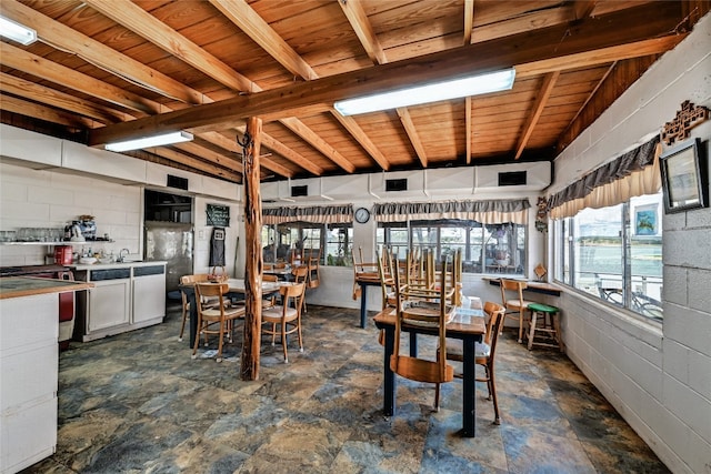 tiled dining room featuring wooden ceiling, a healthy amount of sunlight, and beamed ceiling