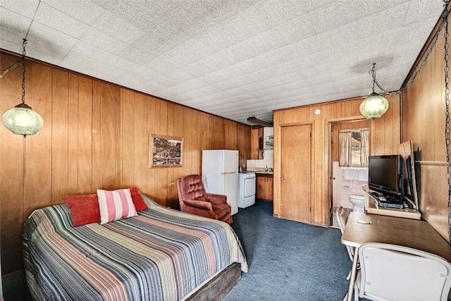 carpeted bedroom featuring white refrigerator and wooden walls