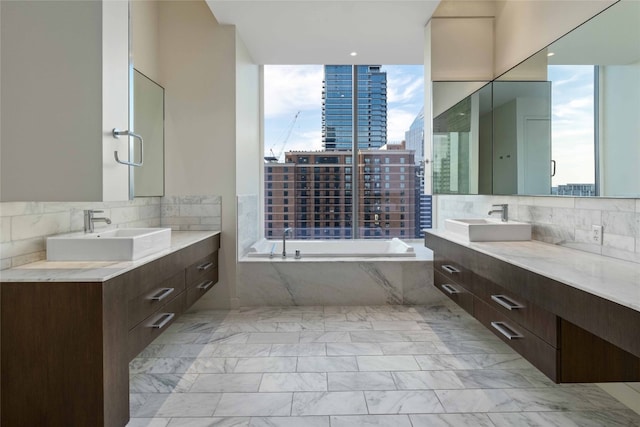 bathroom with tasteful backsplash, vanity, and a bathing tub