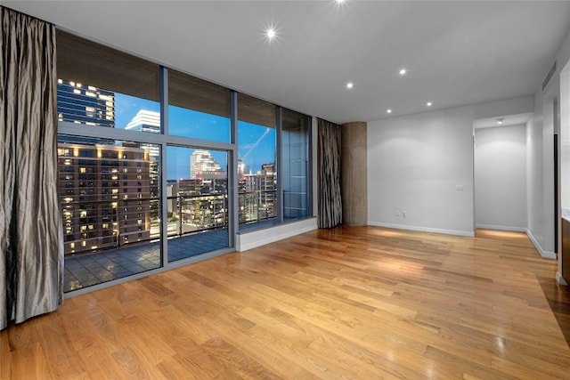 unfurnished room with light wood-type flooring and floor to ceiling windows