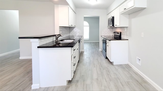 kitchen with stainless steel appliances, tasteful backsplash, light hardwood / wood-style floors, and white cabinets