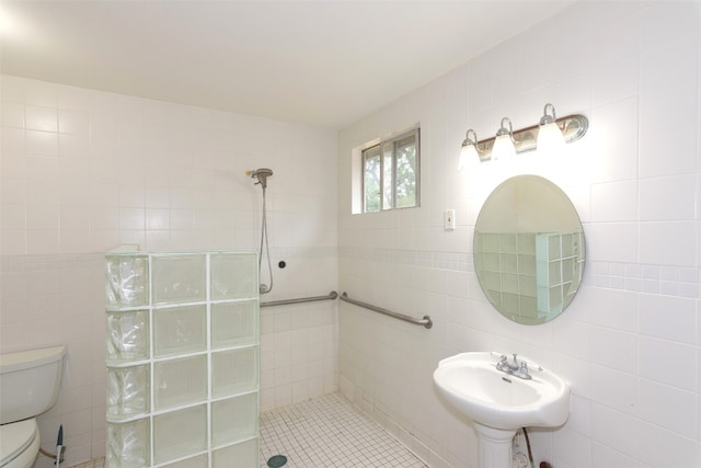 bathroom featuring sink, tiled shower, toilet, and tile walls