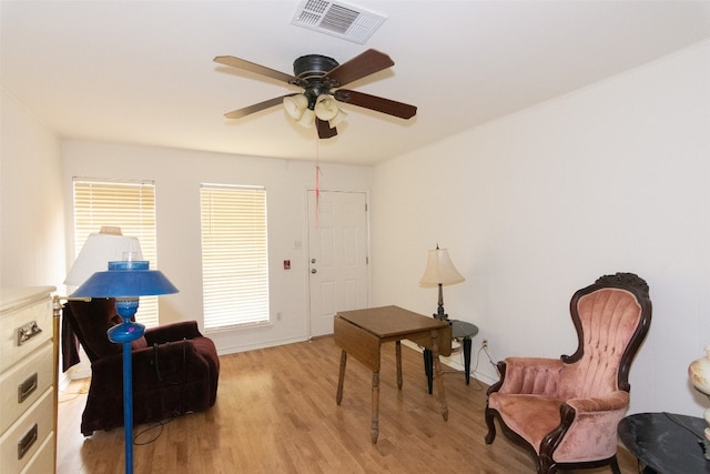 sitting room with ceiling fan and light wood-type flooring