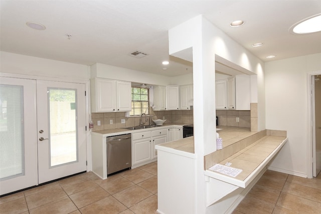 kitchen featuring french doors, sink, white cabinets, dishwasher, and tasteful backsplash