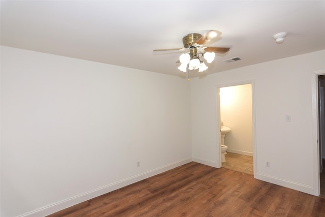 empty room with dark hardwood / wood-style flooring and ceiling fan