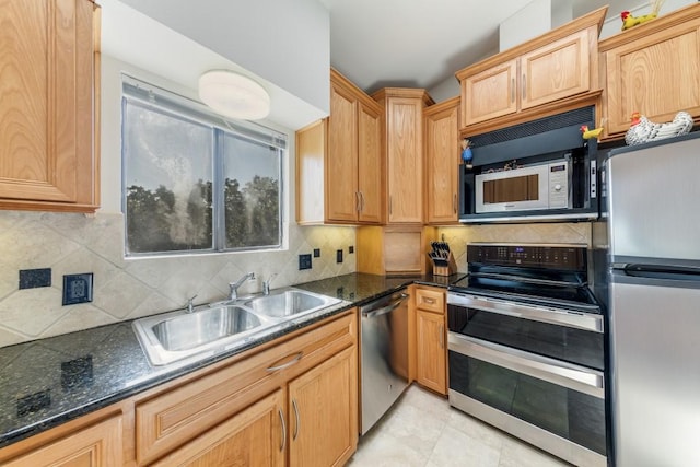 kitchen with sink, light brown cabinets, tasteful backsplash, dark stone counters, and appliances with stainless steel finishes