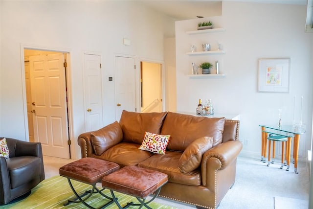 carpeted living room featuring a towering ceiling