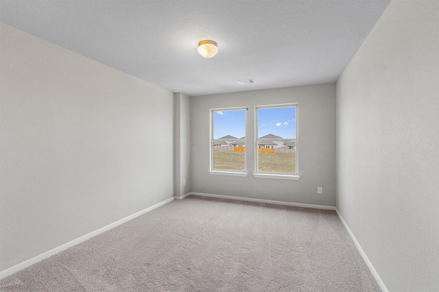 carpeted spare room featuring a textured ceiling