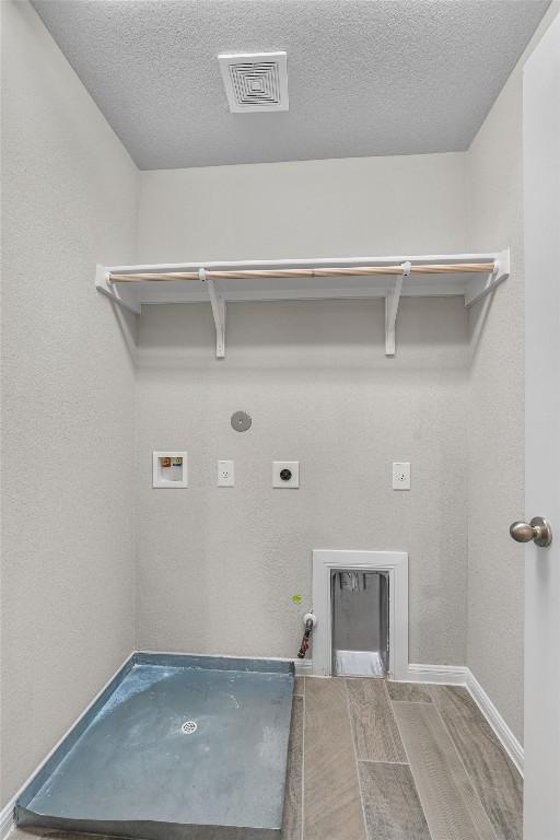 laundry room with gas dryer hookup, hookup for a washing machine, electric dryer hookup, and a textured ceiling