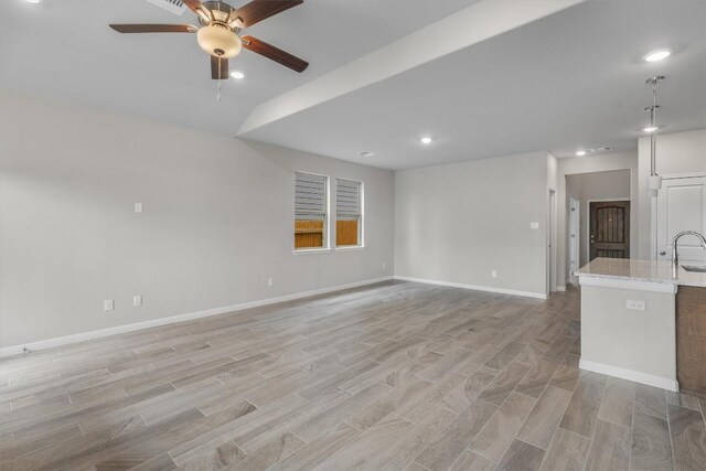 unfurnished living room with sink, ceiling fan, and lofted ceiling