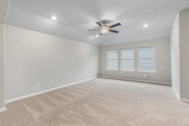 carpeted spare room with ceiling fan