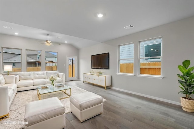 living room featuring light hardwood / wood-style flooring, ceiling fan, and vaulted ceiling