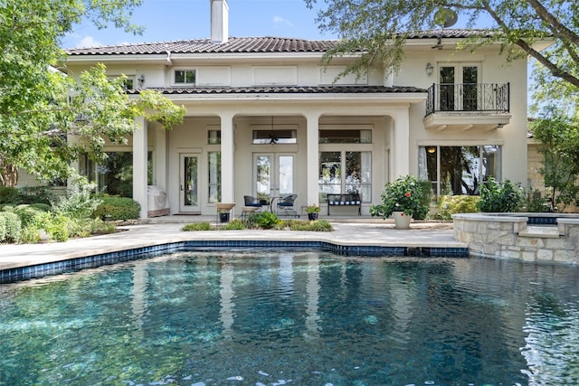 back of property featuring a balcony, a patio area, and french doors