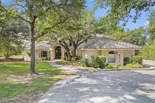 mediterranean / spanish home featuring a front yard