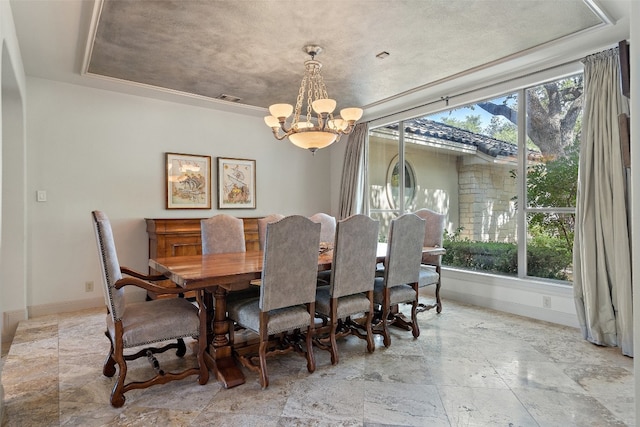 tiled dining space featuring a chandelier and a raised ceiling