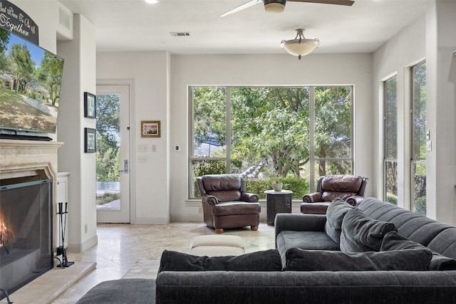 living room featuring light tile flooring and ceiling fan