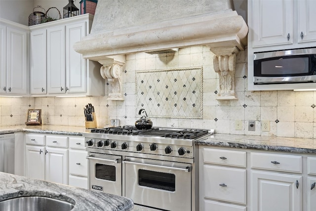 kitchen featuring stainless steel appliances, light stone counters, tasteful backsplash, and white cabinetry