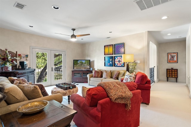 living room featuring ceiling fan, light colored carpet, and french doors