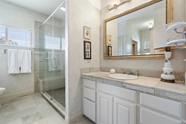 bathroom featuring a shower with door, tile flooring, large vanity, and toilet