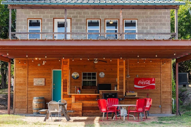 back of property featuring a balcony, ceiling fan, and central air condition unit