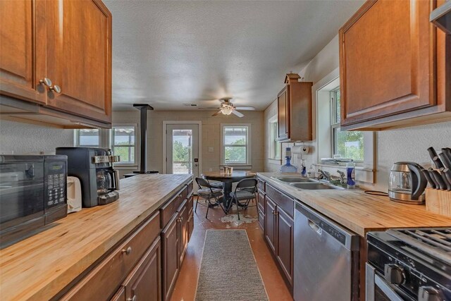 kitchen with black appliances, ceiling fan, butcher block countertops, and sink