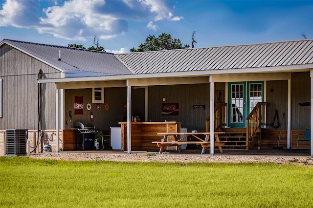95 Loma Ln, Fredericksburg, TX 78624 - back of property with metal roof, a lawn, and central AC unit
