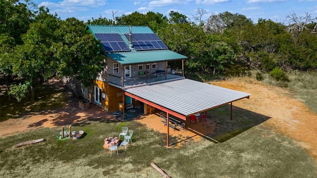 95 Loma Ln, Fredericksburg, TX 78624 - back of property featuring solar panels, metal roof, driveway, a carport, and view of scattered trees