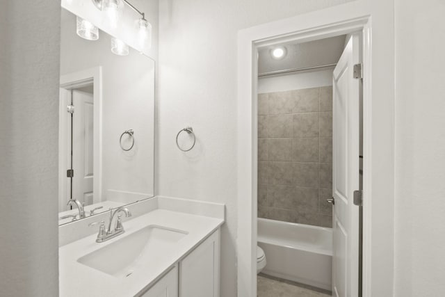 full bathroom featuring vanity, tiled shower / bath combo, and toilet