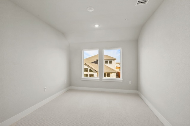 spare room featuring lofted ceiling and carpet