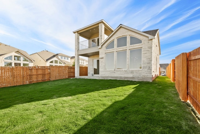 rear view of property with a yard and a balcony