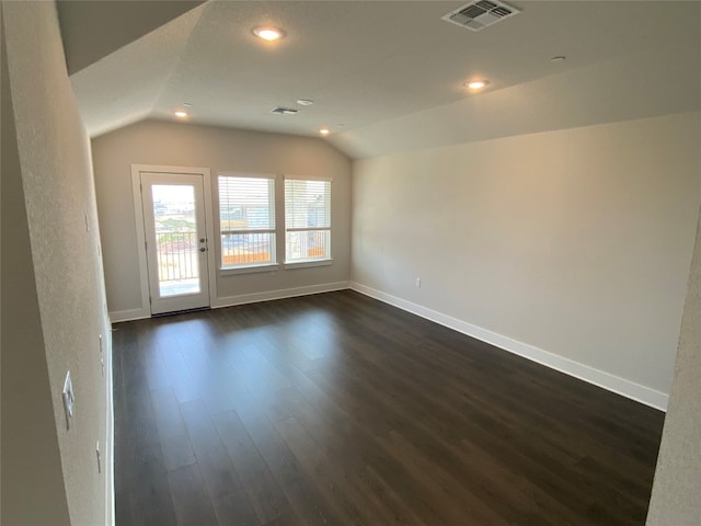 spare room with lofted ceiling and dark hardwood / wood-style flooring