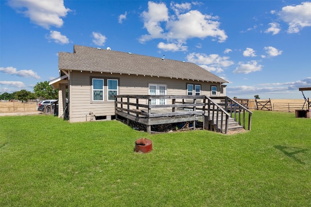 rear view of house featuring a wooden deck and a yard