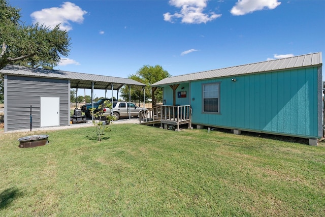 view of yard with a carport, a fire pit, and a storage unit