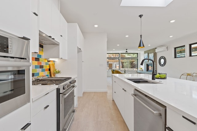 kitchen featuring appliances with stainless steel finishes, sink, a wall mounted air conditioner, and white cabinets