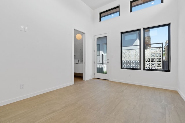 unfurnished room featuring a towering ceiling