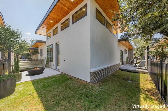 view of side of home featuring a lawn and a deck