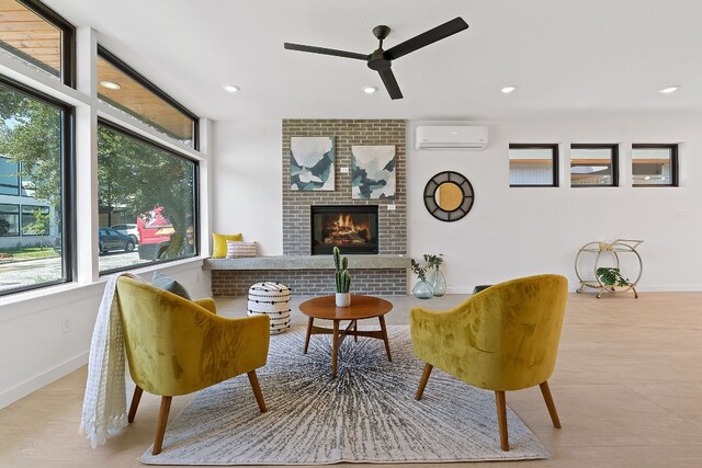 living area featuring an AC wall unit and a fireplace