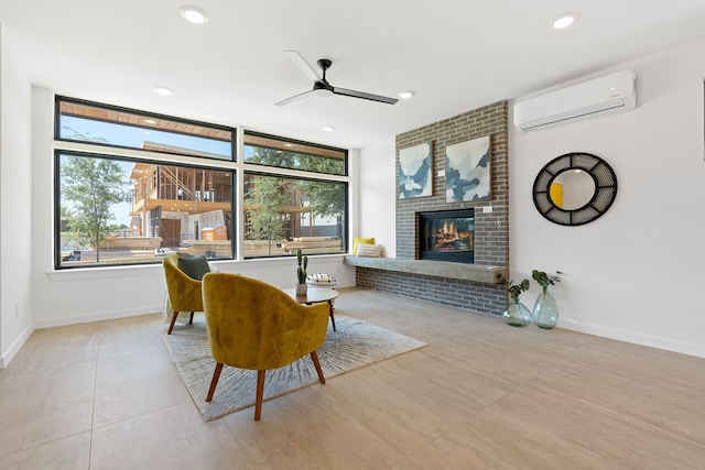 sitting room featuring a brick fireplace, a wall mounted air conditioner, and ceiling fan