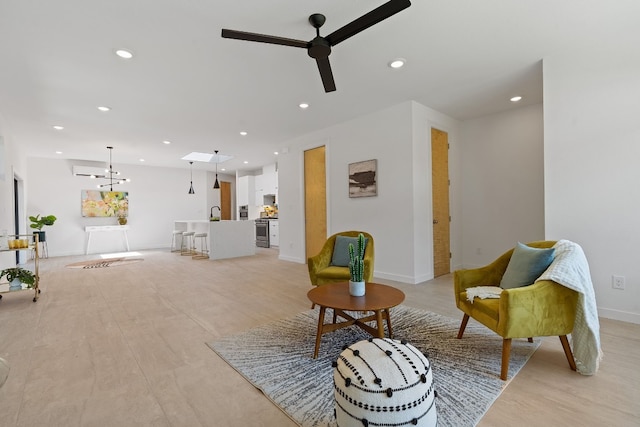 living area with ceiling fan with notable chandelier