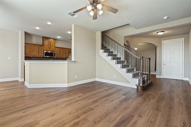 kitchen with kitchen peninsula, ceiling fan, and wood-type flooring