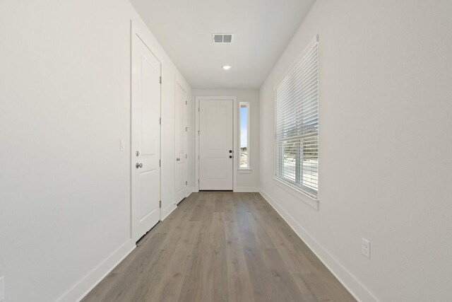 entryway featuring visible vents, baseboards, and wood finished floors