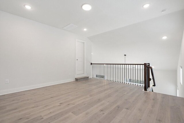 empty room featuring light wood finished floors, visible vents, recessed lighting, and baseboards