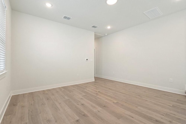 unfurnished room with recessed lighting, baseboards, visible vents, and light wood-type flooring