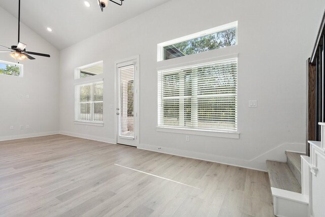 foyer entrance with high vaulted ceiling, light wood-style flooring, baseboards, and ceiling fan