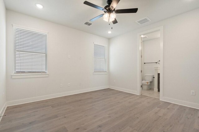 spare room with visible vents, baseboards, and wood finished floors