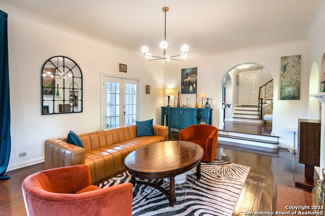 living room with french doors, an inviting chandelier, and dark hardwood / wood-style flooring