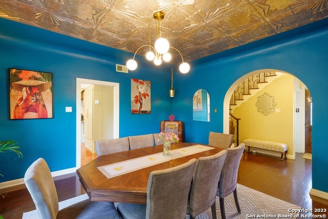 dining space with a notable chandelier and dark hardwood / wood-style flooring