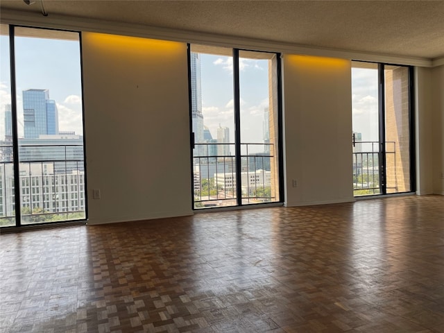 unfurnished room featuring floor to ceiling windows, a textured ceiling, and dark parquet flooring