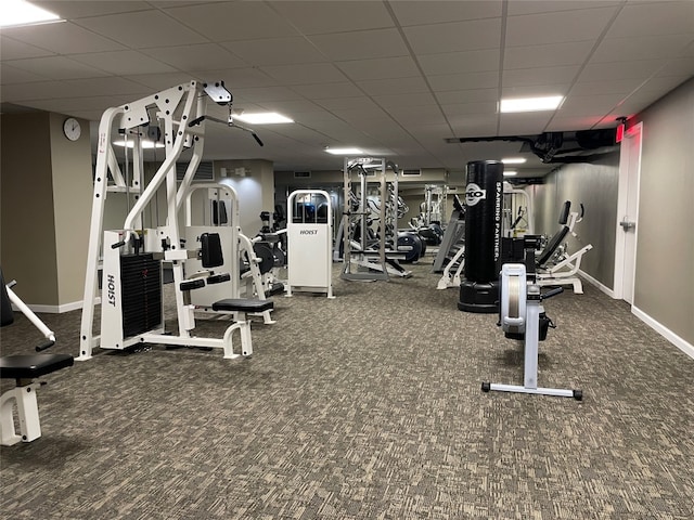 gym with a drop ceiling and dark carpet